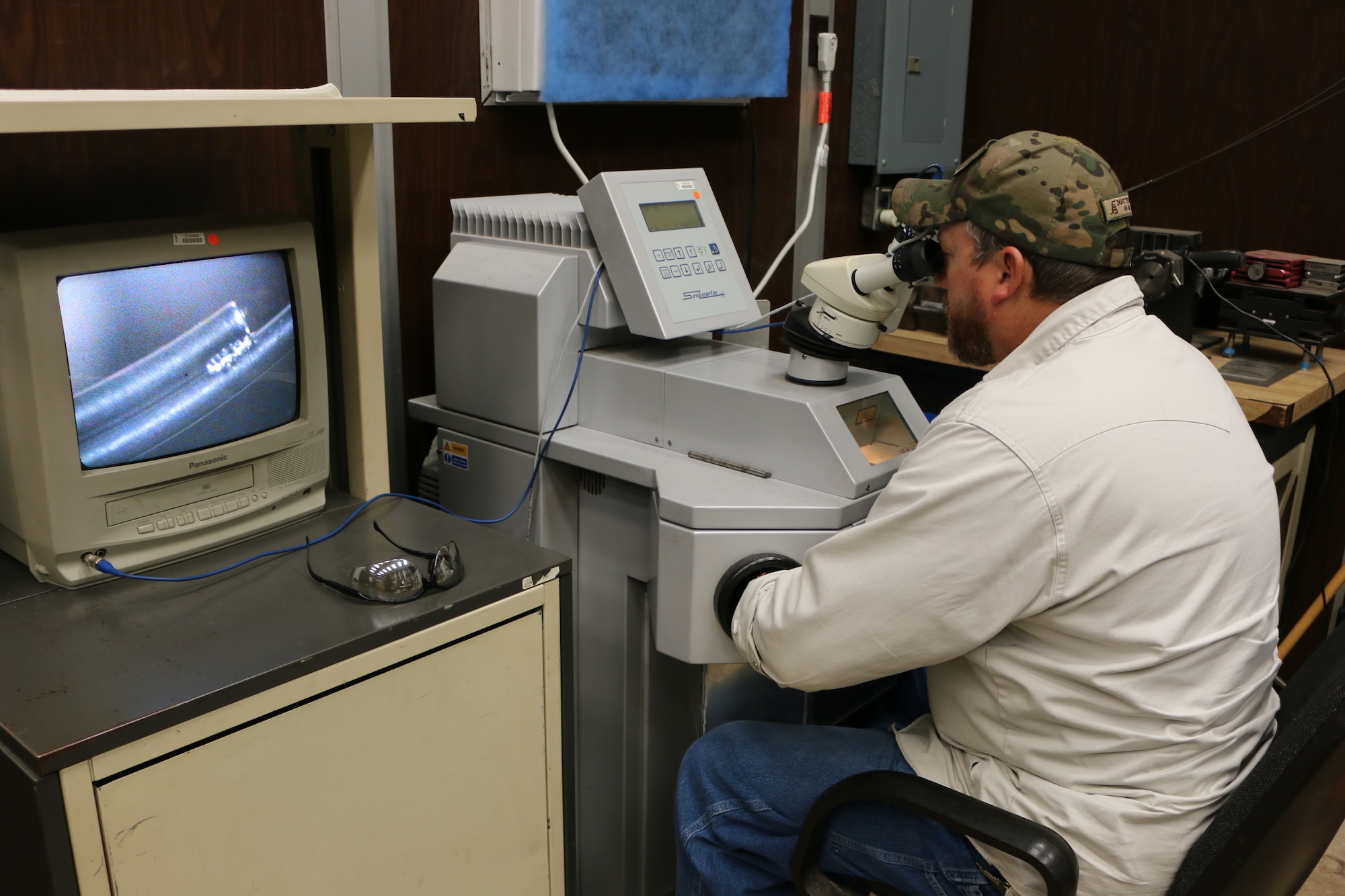 Inside Machinist John Adams completes laser welding on two small pieces of metal in the Model and Machine Shop at Arnold Air Force Base. The screen to Adams’ left provides an enlarged display of the welding being conducted. Laser welding is one of multiple welding methods craft personnel across Arnold perform to support general operations and testing. (U.S. Air Force photo by Brad Hicks)