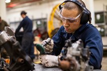 Lance Cpl. Alexander Garcia strips rust from engine parts Jan. 8, 2019, at Camp Kinser, Okinawa, Japan. Marines with Component Repair Platoon, General Support Maintenance Company, 3rd Maintenance Battalion, Combat Logistics Regiment 35, 3rd Marine Logistics Group, clean, rebuild and repair parts of motor vehicles to ensure that they are serviceable. Garcia, a native of Las Vegas, Nevada, is a motor transportation mechanic with CRP, GSM Co., 3rd Maint. Bn., CLR-35, 3rd MLG. (U.S. Marine Corps photo by Lance Cpl. Terry Wong)