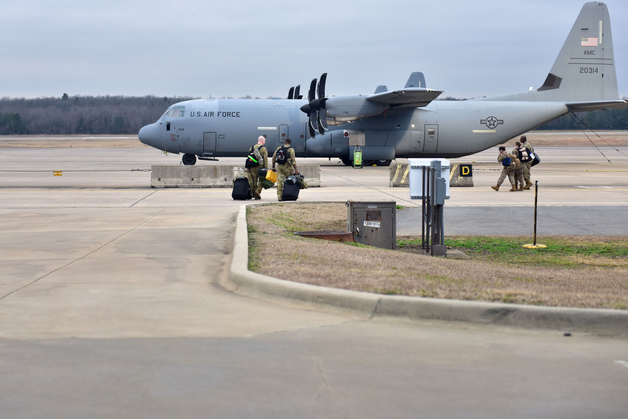 Men walk towards C-130s.