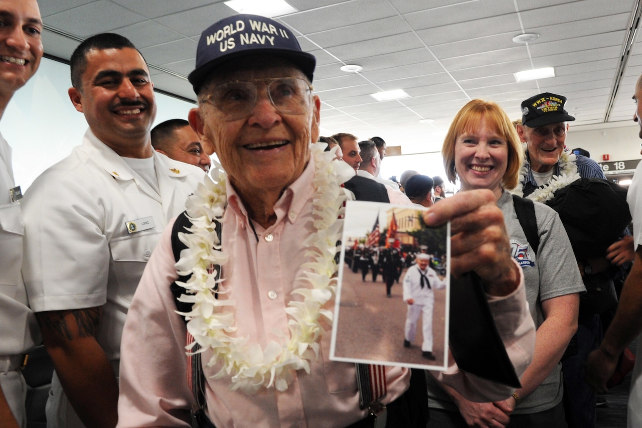 World War II veteran shows an old photo of himself.