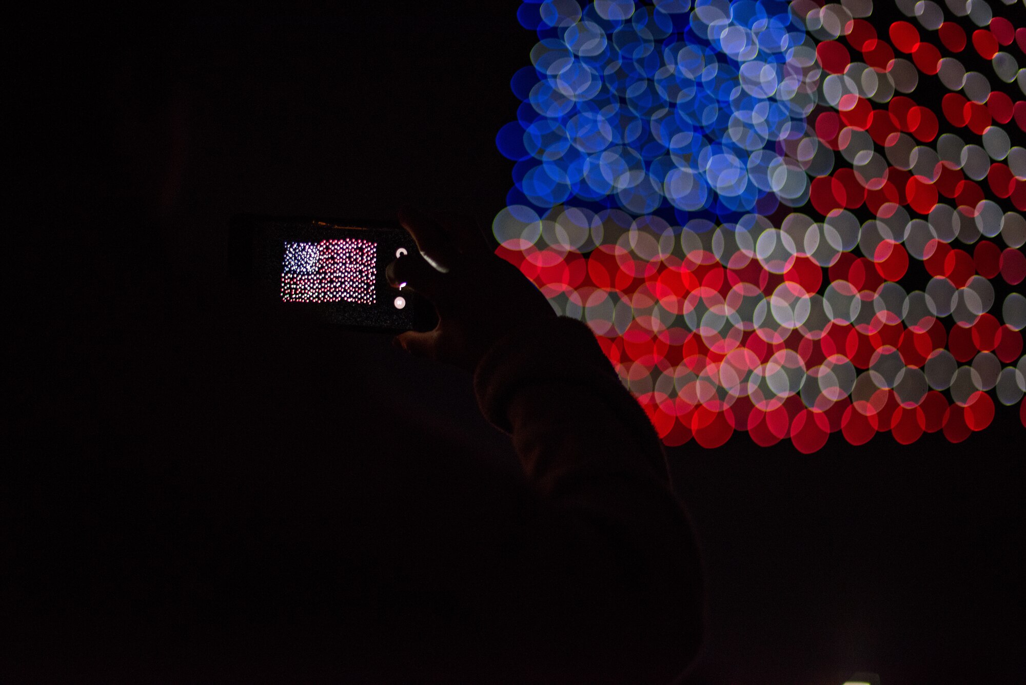 An audience member takes a photo during the Intel Shooting Star Drone light show at Travis Air Force Base, Calif., July 5, 2018. The drones conducted a show consisting of various designs meant to highlight both the U.S. Air Force's and Travis' history. (U.S. Air Force photo by Master Sgt. Joey Swafford)