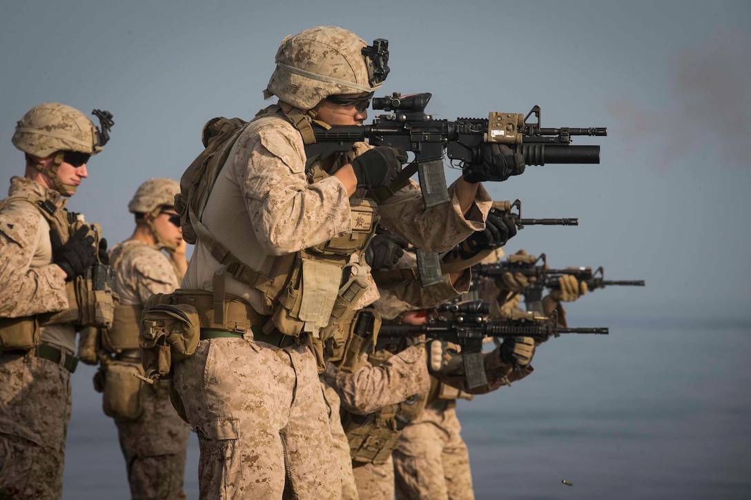 Marine Corps fire weapons aboard a ship.