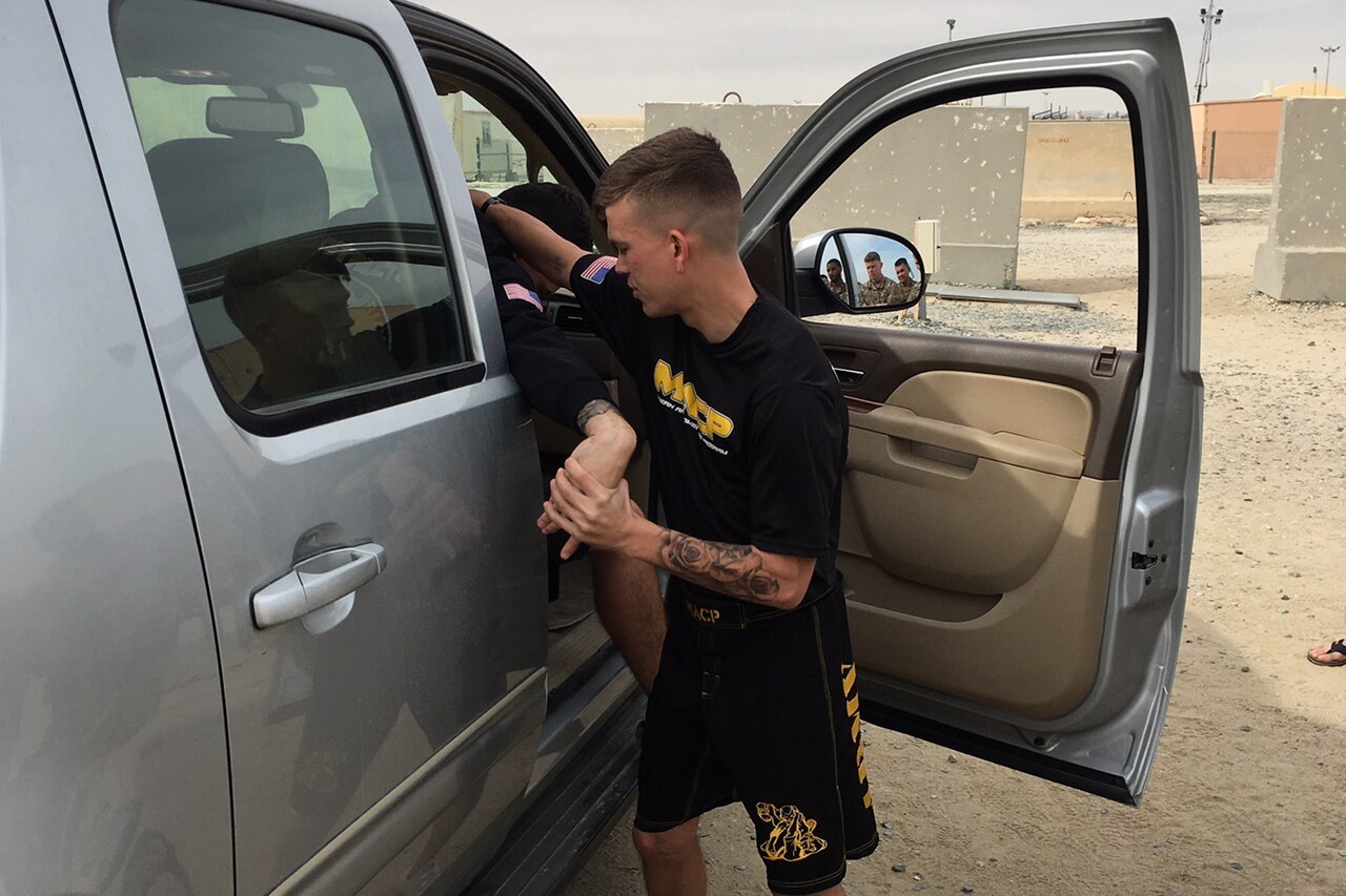 Soldier removes a suspect from a vehicle