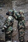 Two U.S. Air Force Airmen practice a new method of mission-oriented protective posture (MOPP) exchange processing during a newly-implemented chemical, biological, radiological and nuclear defense training course exercise at Joint Base Elmendorf-Richardson, Alaska, Jan. 8, 2019. One of the key changes made embraces the reintegration of hands-on, in-person instruction, and reduces computer based training, allowing Airmen to receive a more tailored learning experience. (U.S. Air Force photo by Airman 1st Class Crystal A. Jenkins)