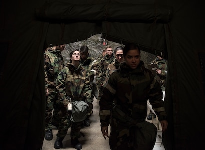 A group of U.S. Air Force Airmen seek shelter during a newly-implemented chemical, biological, radiological and nuclear defense training course exercise at Joint Base Elmendorf-Richardson, Alaska, Jan. 8, 2019. One of the key changes made embraces the reintegration of hands-on, in-person instruction, and reduces computer based training, allowing Airmen to receive a more tailored learning experience. (U.S. Air Force photo by Airman 1st Class Crystal A. Jenkins)
