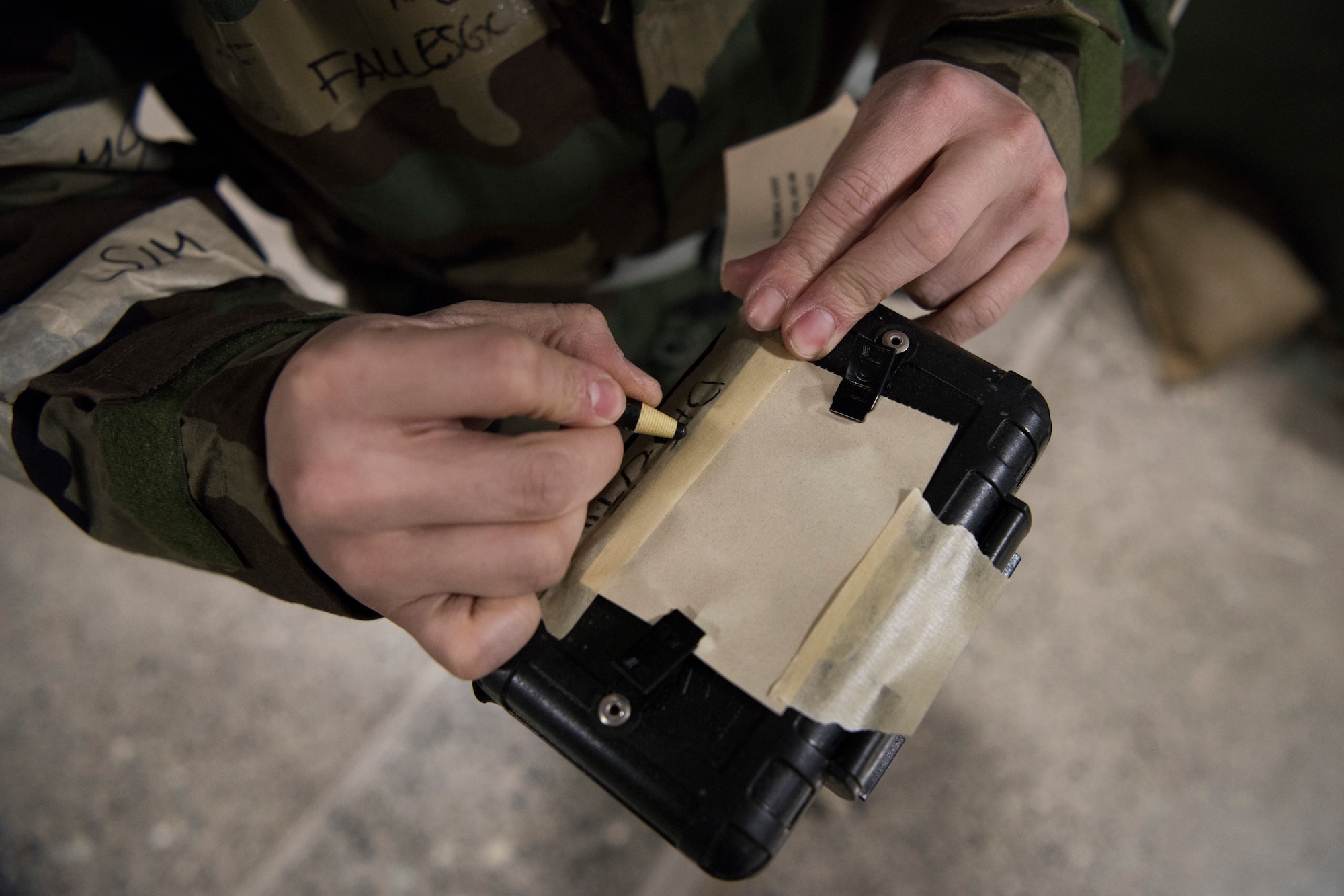 U.S. Air Force Tech. Sgt. John Fallesgon, 673d Force Support Squadron Fitness Assessment Cell noncommissioned officer in charge, writes on M-8 paper during a newly-implemented chemical, biological, radiological and nuclear defense training course exercise at Joint Base Elmendorf-Richardson, Alaska, Jan. 8, 2019. One of the key changes made embraces the reintegration of hands-on, in-person instruction, and reduces computer based training, allowing Airmen to receive a more tailored learning experience. (U.S. Air Force photo by Airman 1st Class Crystal A. Jenkins)