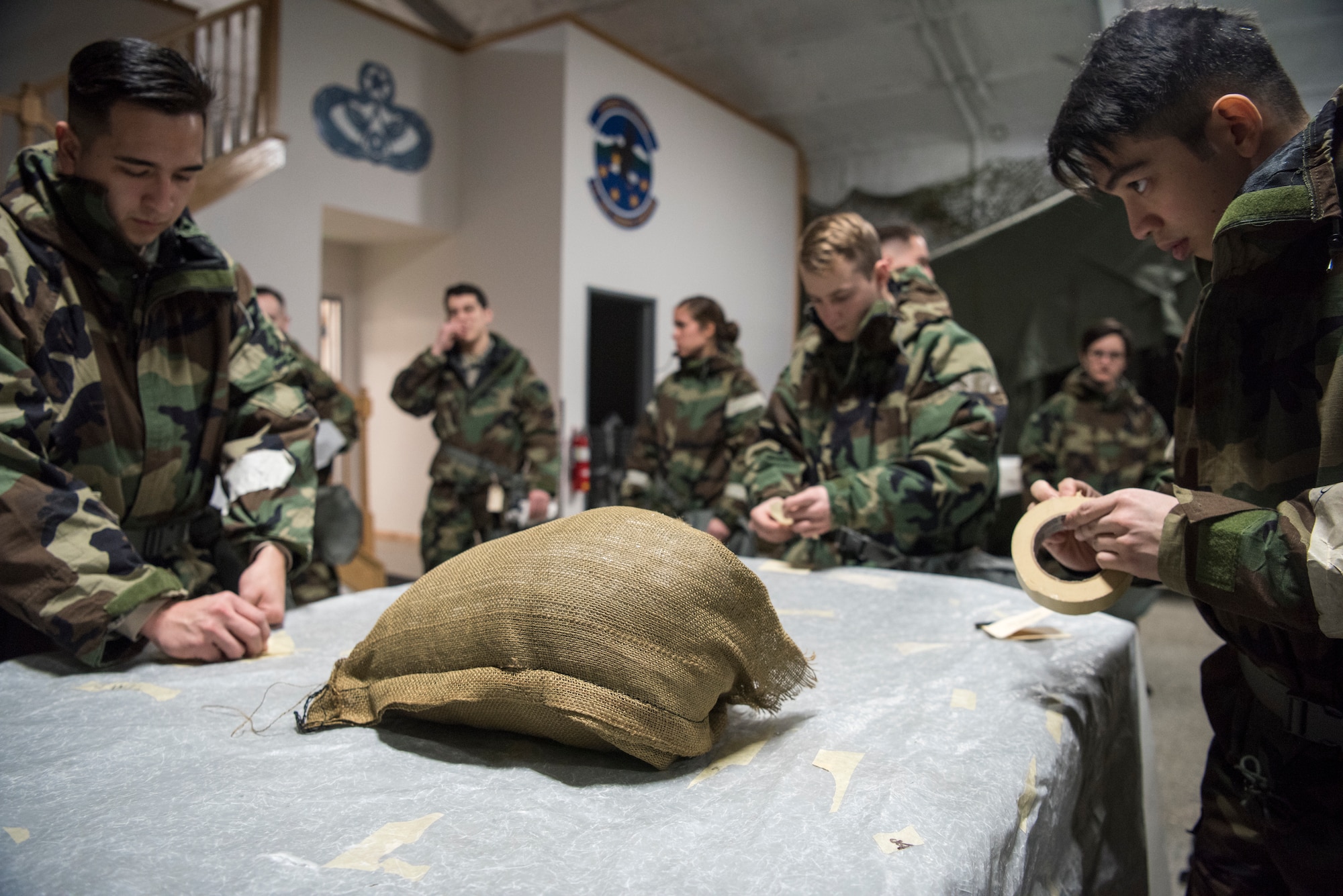 A group of U.S. Air Force Airmen place M-8 paper on a simulated piece of equipment during a newly-implemented chemical, biological, radiological and nuclear defense training course exercise at Joint Base Elmendorf-Richardson, Alaska, Jan. 8, 2019. One of the key changes made embraces the reintegration of hands-on, in-person instruction, and reduces computer based training, allowing Airmen to receive a more tailored learning experience. (U.S. Air Force photo by Airman 1st Class Crystal A. Jenkins)