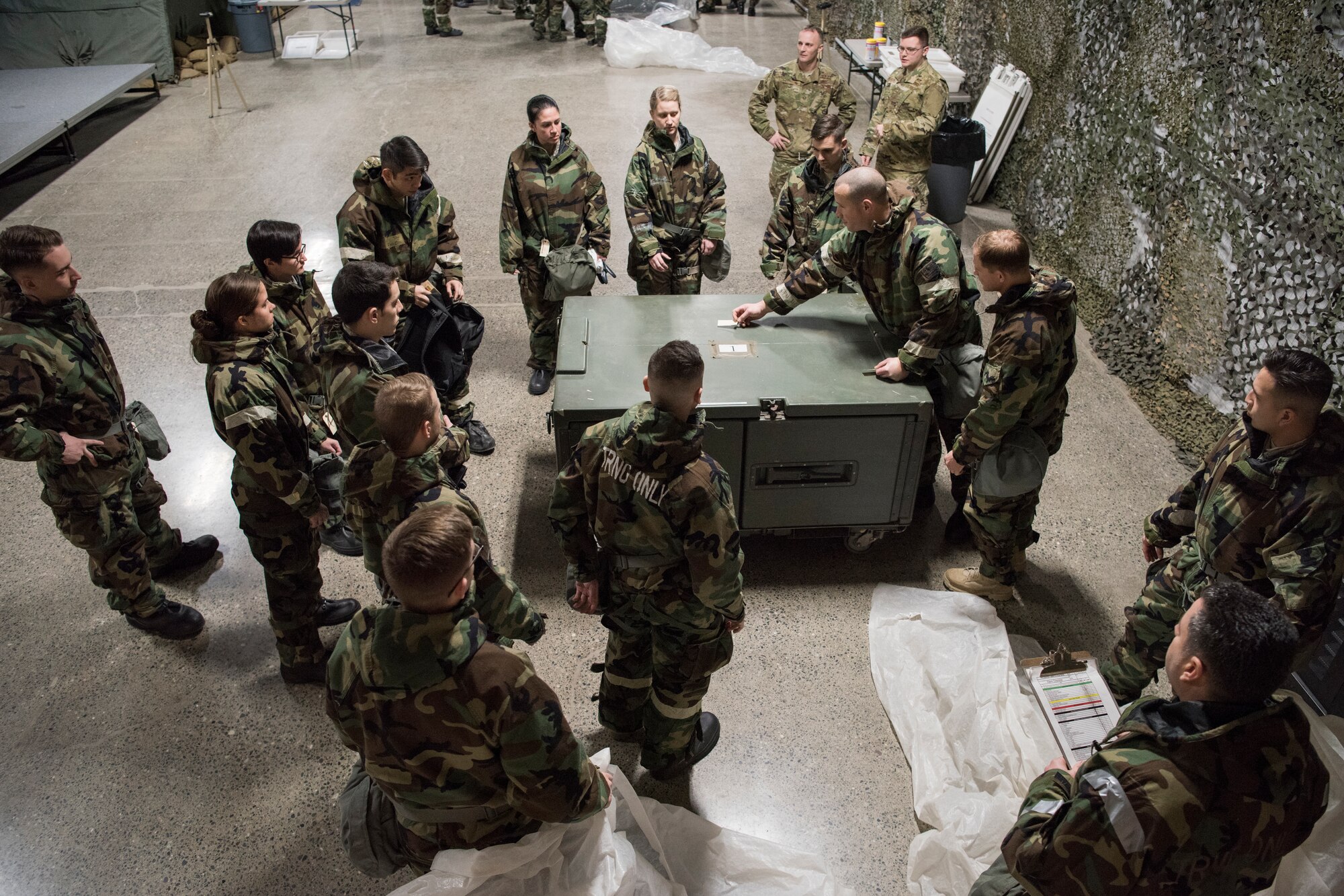 U.S. Air Force Master Sgt. Michael Smith, 3rd Air Support Operations Squadron superintendent, directs classmates on proper placement of M-8 paper during a newly-implemented chemical, biological, radiological and nuclear defense training course drill at Joint Base Elmendorf-Richardson, Alaska, Jan. 8, 2019. One of the key changes made embraces the reintegration of hands-on, in-person instruction, and reduces computer based training, allowing Airmen to receive a more tailored learning experience. (U.S. Air Force photo by Airman 1st Class Crystal A. Jenkins)