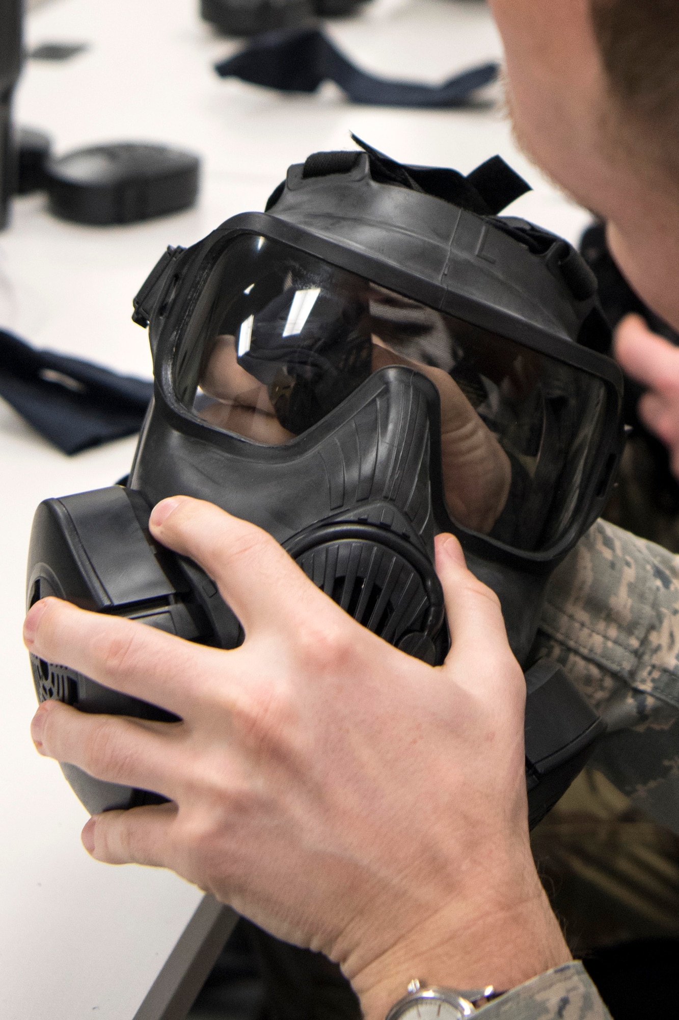 U.S. Air Force Staff. Sgt. Charles Danowski, a 673d Medical Support Squadron medical laboratory technician, cleans his the lens on his M50 series protective mask during a newly-implemented chemical, biological, radiological and nuclear defense training course at Joint Base Elmendorf-Richardson, Alaska, Jan. 8, 2019. One of the key changes made embraces the reintegration of hands-on, in-person instruction, and reduces computer based training, allowing Airmen to receive a more tailored learning experience.