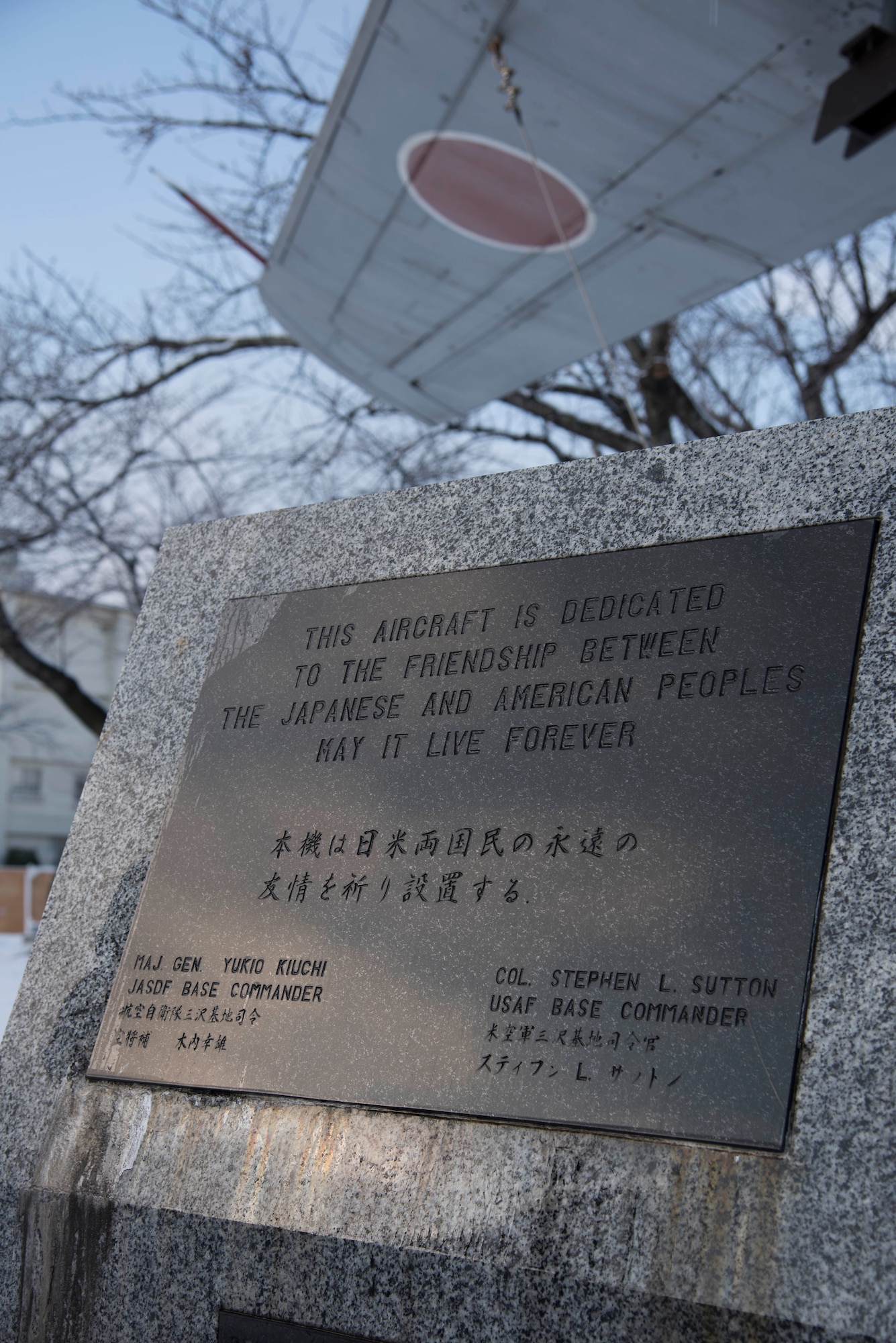 An F-86F Sabre dedication plaque sits in Risner Circle at Misawa Air Base, Japan, Dec. 18, 2018. After the first Combined Air Festival in 1980, the Japanese and American base commanders decided to use the F-86 as a symbol of the Japan-U.S. friendship. Service members from Hamamatsu Air Base, Japan, dissembled the aircraft and it arrived at Misawa AB on July 3, 1981, to be reassembled and displayed. Engraved on this plaque is the statement, “This aircraft is dedicated to the friendship between the Japanese and American peoples. May it live forever.” (U.S. Air Force photo)