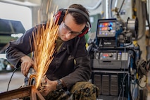 Lance Cpl. David A. Hill grinds a part Jan. 9, 2019 at Camp Kinser, Okinawa, Japan. Machinists and welders with General Support Maintenance Company, 3rd Maintenance Battalion, Combat Logistics Regiment 35, 3rd Marine Logistics Group fabricate, modify and repair parts for vehicles, weapons and other accessories. Hill is a welder with GSM Co., 3rd Maint. Bn., CLR-35, 3rd MLG. Hill is a native of Garland, Texas. (U.S. Marine Corps photo by Lance Cpl. Terry Wong)