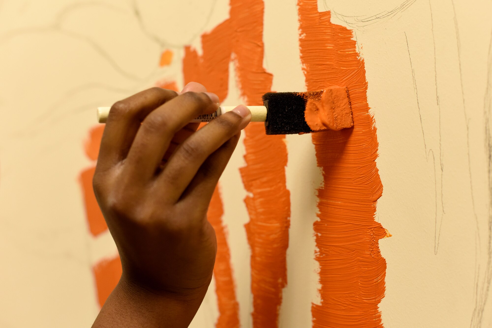 Volunteer Nadja Ellis paints a tiger for a mural in the 100th Communications Squadron building at RAF Mildenhall, England, Dec. 20, 2018.  The tiger is part of a children’s picture book-themed mural covering the walls of the Mothers’ Room, or lactation room, in the squadron.  (U.S. Air Force photo by Senior Airman Lexie West)