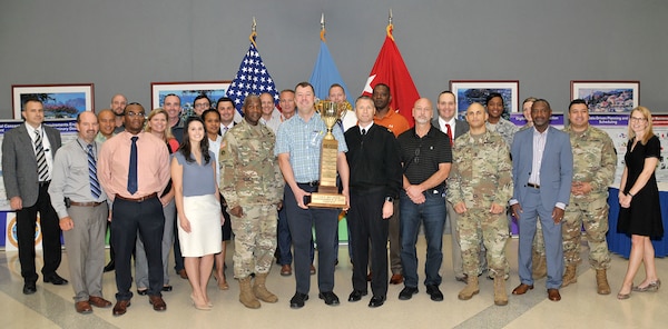 Participants who helped DLA win the 2018 Commander’s Cup pose with DLA Director Army Lt. Gen. Darrell Williams (front row, fourth from left) and Navy Command Master Chief Shaun Brahmsteadt (front row, sixth from left), DLA senior enlisted leader. Holding the trophy is Andy Green of DLA Strategic Materials, who organized DLA’s participation in the events throughout the year.