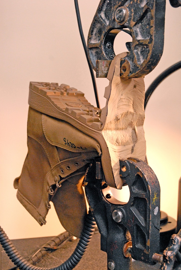 The sole of a military-issue boot is ripped apart by the Product Test Center-Analytical Instron tensile tester. Using the interchangeable jaws of the machine, footwear can be tested to ensure the soles have the proper bond strength and won’t separate under field conditions.