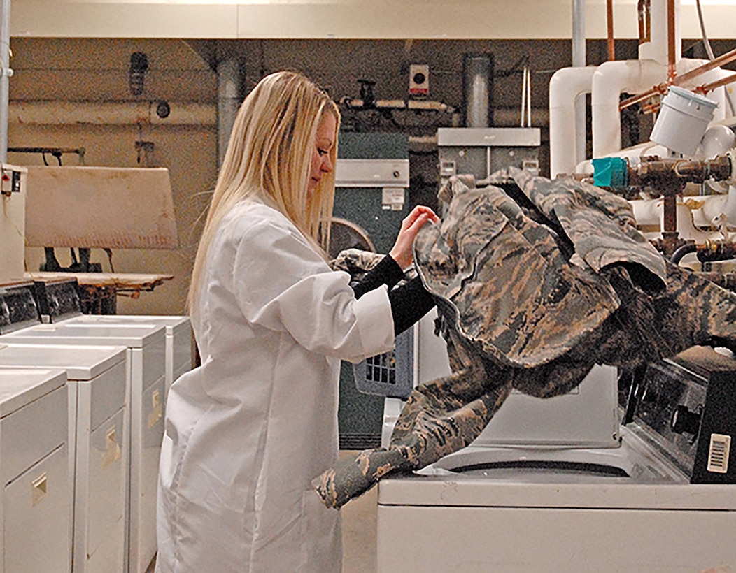 Product Test Center-Analytical scientist Nicole Dysart washes an Air Force jacket. Specifications the lab tests for include maintaining certain qualities after multiple washes, so the scientists often do laundry at work.