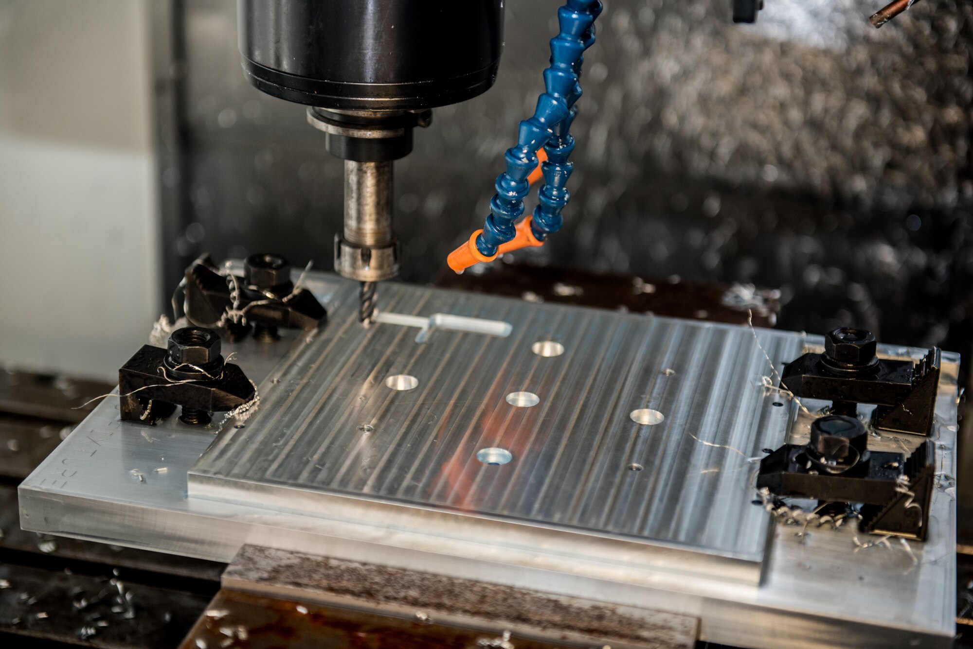 A vertical mill computer numeric control system drills into an aluminum plate at Dover Air Force Base, Delaware, Jan. 6, 2019. The 512th Airlift Wing volunteered to manufacture HH-60G Pave Hawk helicopter plates to assist the 920th Rescue Wing at Patrick AFB, Florida. (U.S. Air Force photo by Staff Sgt. Damien Taylor)