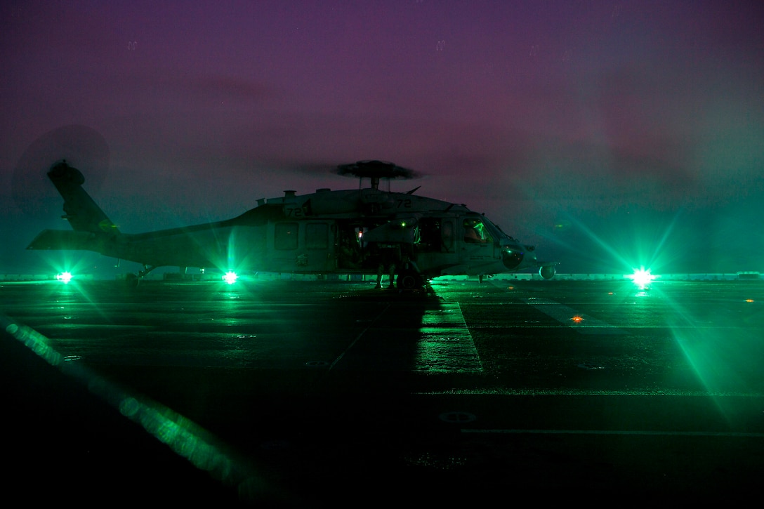 A helicopter at night parked on the ground.