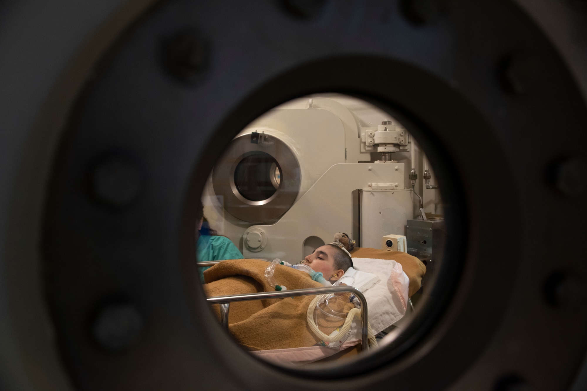 Jeremiah Harutyunyan, who goes by the nickname JJ, sleeps through a session of hyperbaric oxygen therapy treatment, at David Grant USAF Force Medical Center, Travis Air Force Base, California, Dec. 8, 2019.  HBOT provides the application of 100 percent oxygen, which is proven to increased blood flow, promotes cell growth and new blood vessel formation along with other additional benefits. (U.S. Air Force Photo by Heide Couch)
