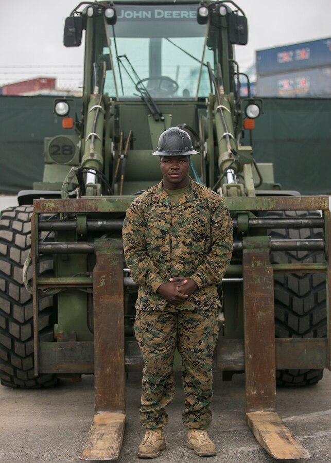 SAN PEDRO, Calif. – Sgt. Alimamy Kamara, a heavy equipment operator with Marine Wing Support Squadron (MWSS) 373, Marine Wing Support Group (MWSG) 37, 3rd Marine Aircraft Wing, poses for a photo at San Pedro, Calif., Dec. 14. Kamara transported equipment onto a barge headed to Catalina Island as part of the “Airport in the Sky” reconstruction project. The completion of phase one for the Catalina runway project consisted of the embarkation of utility and engineer assets. (U.S. Marine Corps photo by Lance Cpl. Juan Anaya)