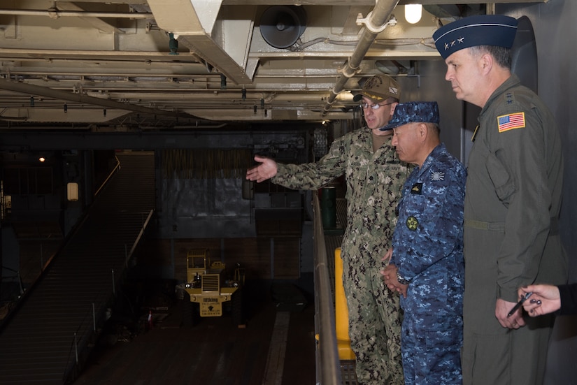 Military members tour a ship.