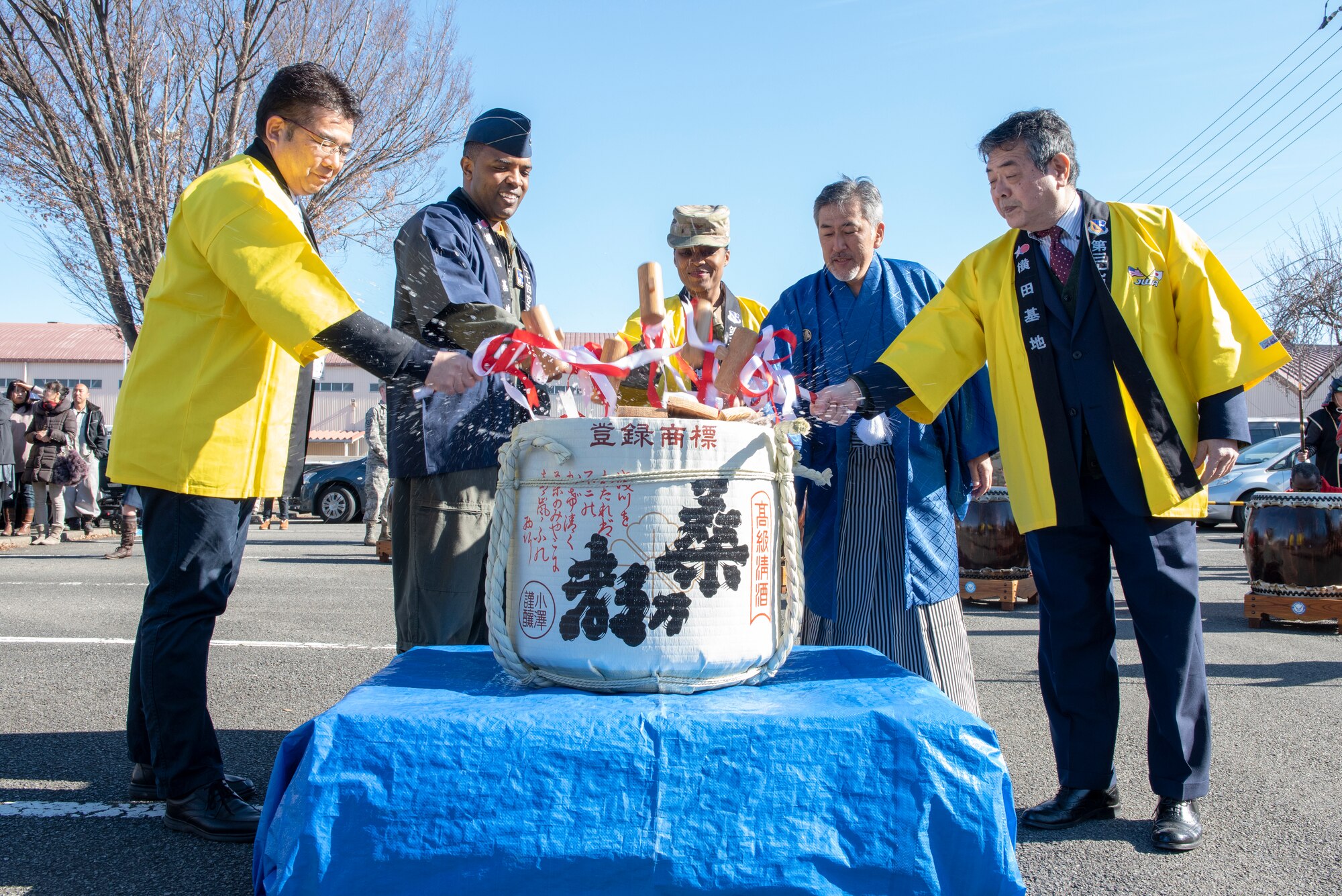 Col. Otis C. Jones, 374th Airlift Wing commander and members of the Japanese Welfare Association (JWA) perform a Kagami-biraki, or sake barrel opening ceremony, at Japanese Culture Day at Yokota Air Base, Japan, Jan. 11, 2019.