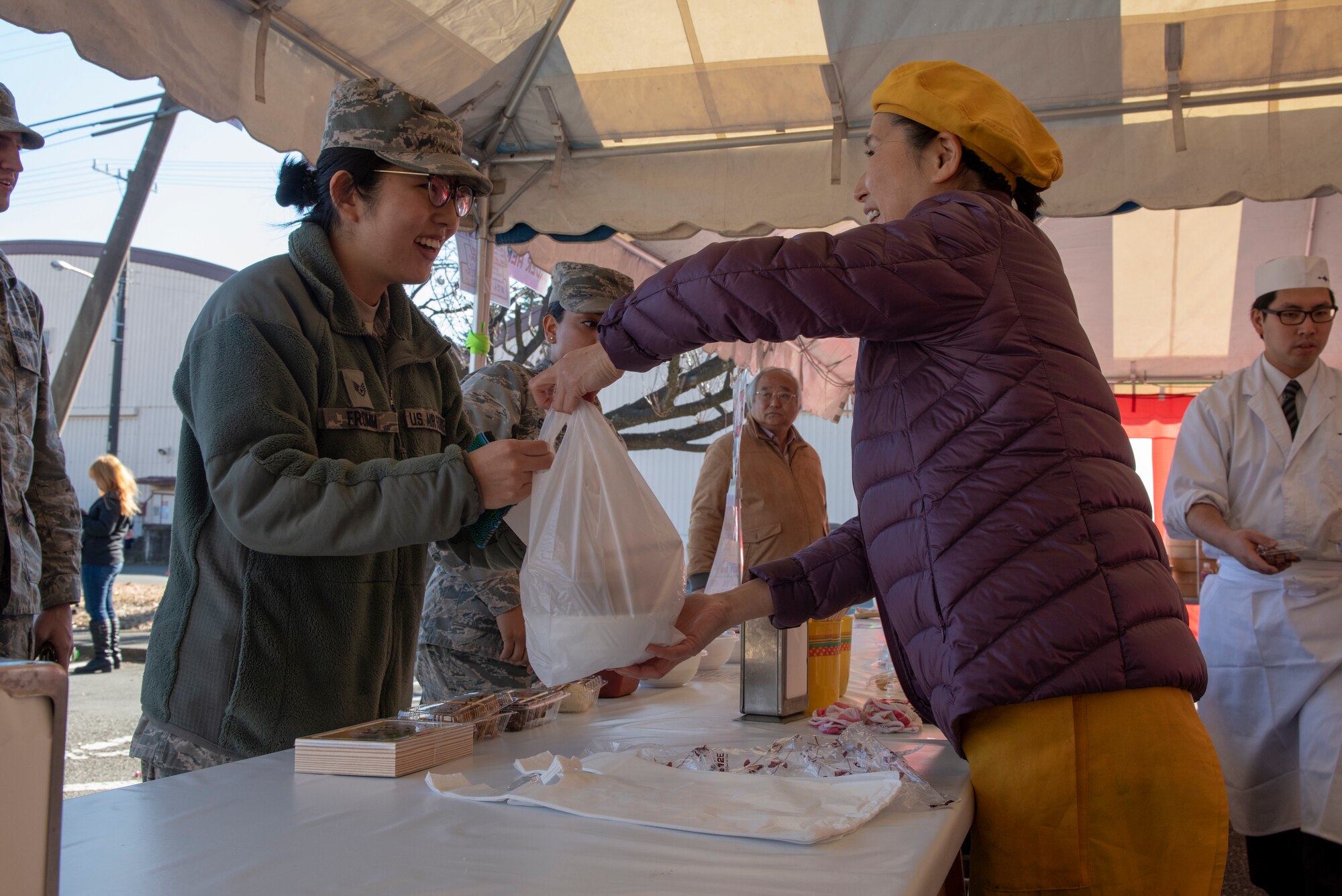 A member of the Japanese Welfare Association provides food to a member of Team Yokota at the annual Japanese Culture Day at Yokota Air Base, Japan, Jan. 11, 2019.