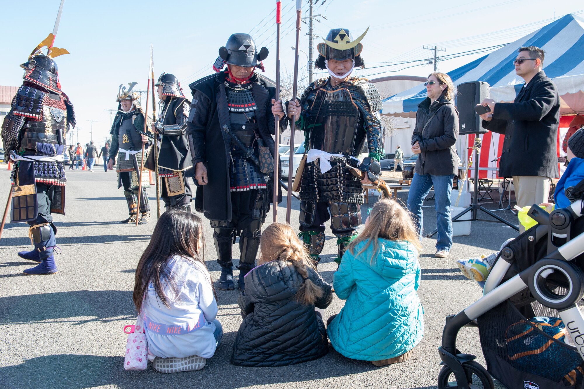 A pair of men in traditional samurai armor have a chat with a set of young girls at the annual Japanese Culture Day at Yokota Air Base, Japan, Jan. 11, 2019.