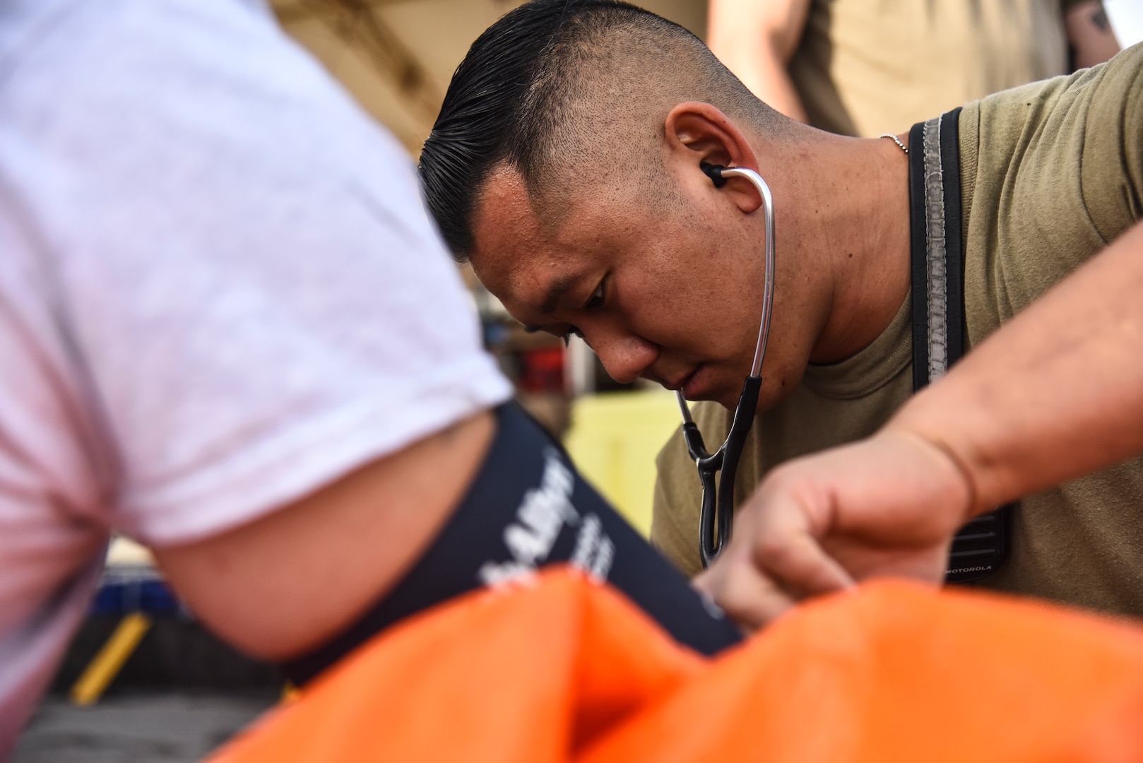 U.S. Air Force Senior Airman Peter Yoon, 380th Expeditionary Civil Engineer Squadron Fire Department firefighter, checks an Airman’s vitals during a hazardous materials exercise at Al Dhafra Air Base, United Arab Emirates, Jan. 4, 2019. The 380th ECES Fire Department and Emergency Management flights conducted a joint-agency hazardous material exercise for training purposes. (U.S. Air Force photo by Senior Airman Mya M. Crosby)
