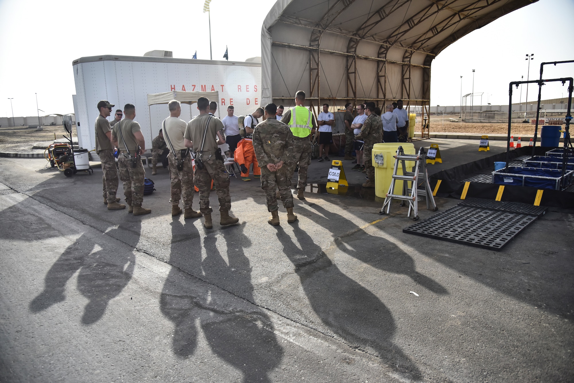 U.S. Airmen assigned to the 380th Expeditionary Civil Engineer Squadron gather for a safety briefing during a hazardous materials exercise at Al Dhafra Air Base, United Arab Emirates, Jan. 4, 2019. The exercise was designed to be a Department of Defense certification for three Airmen in the Fire Department and an annual refresher training for the Emergency Management flight. The Airmen were instructed to contain leaks on a pressurized chlorine cylinder, a one-ton cryo-tank, and a rail car, all after donning a Level-A suit. (U.S. Air Force photo by Senior Airman Mya M. Crosby)