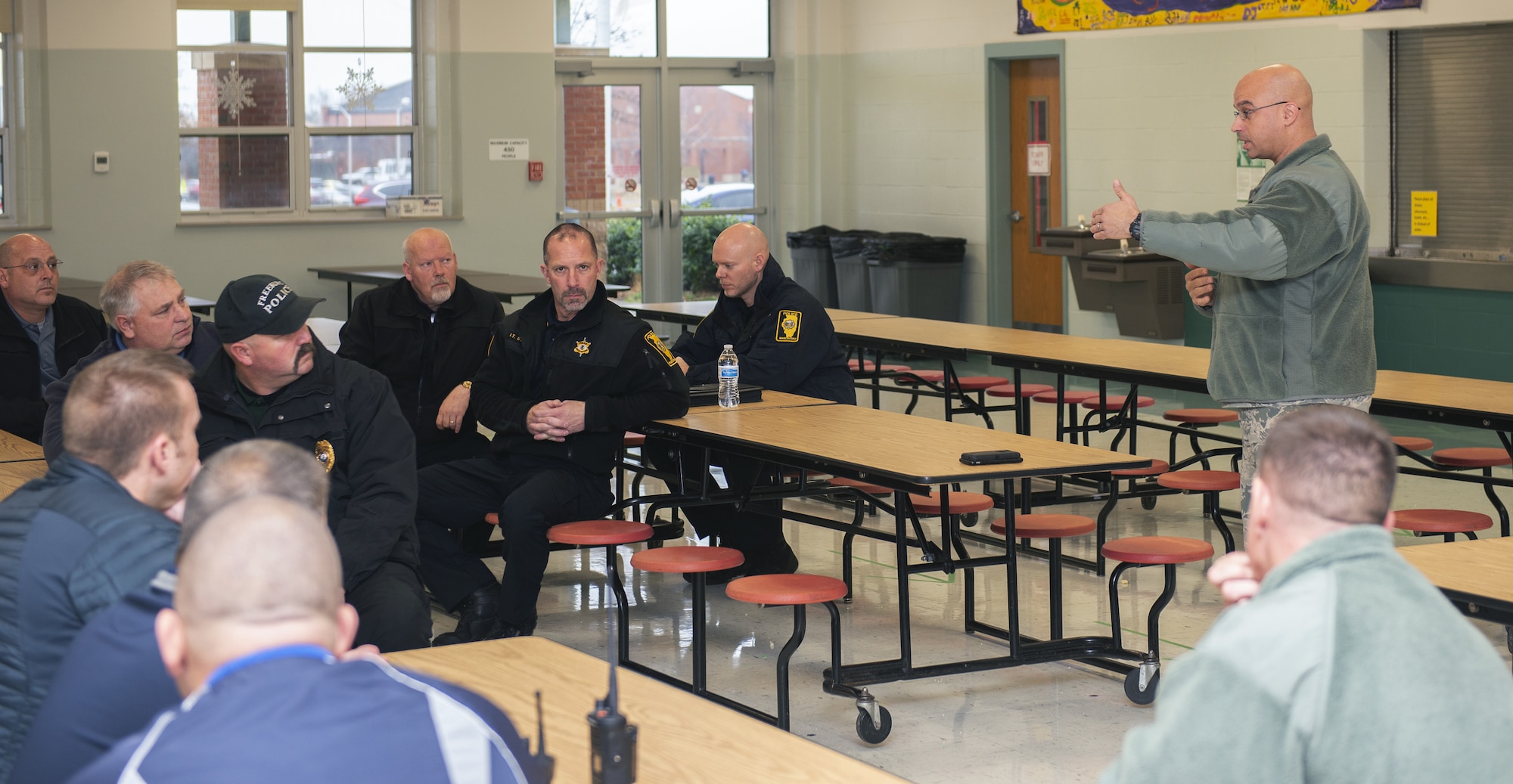Lt. Col. Yon Dugger, 375th Security Forces Squadron commander, speaks to members of the St. Clair County Police Department and Scott Elementary School, Dec. 21, 2018, at Scott Air Force Base, Illinois. The organizations met to discuss base procedures in the event of an active shooter incident to include a walkthrough of the school to locate all possible exit points and potential safe rooms in the building.