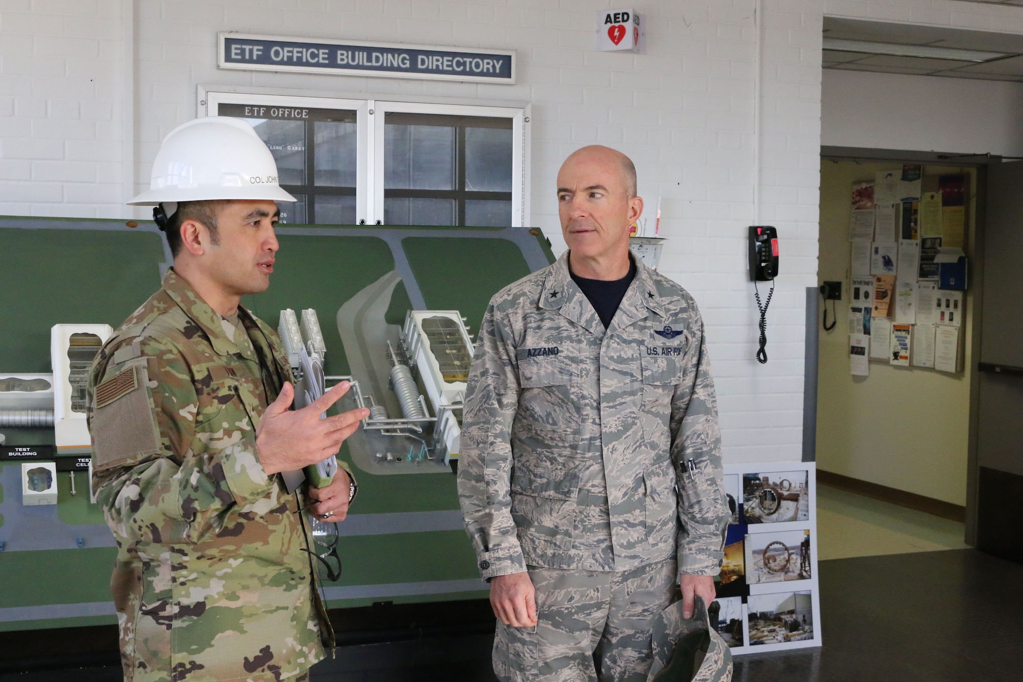 Brig. Gen. Christopher Azzano, commander of the Air Force Test Center, right, is briefed by AEDC Test Systems Sustainment Chief Col. John Tran before his tour of the Engine Test Facility at Arnold Air Force Base. Azzano and other AFTC leadership visited Arnold Air Force Base in mid-November to take part in the 2018 AFTC Strategic Offsite, Azzano’s first offsite since assuming the role of AFTC commander in August. (U.S. Air Force photo by Brad Hicks) (This image was altered by obscuring badges for security purposes)