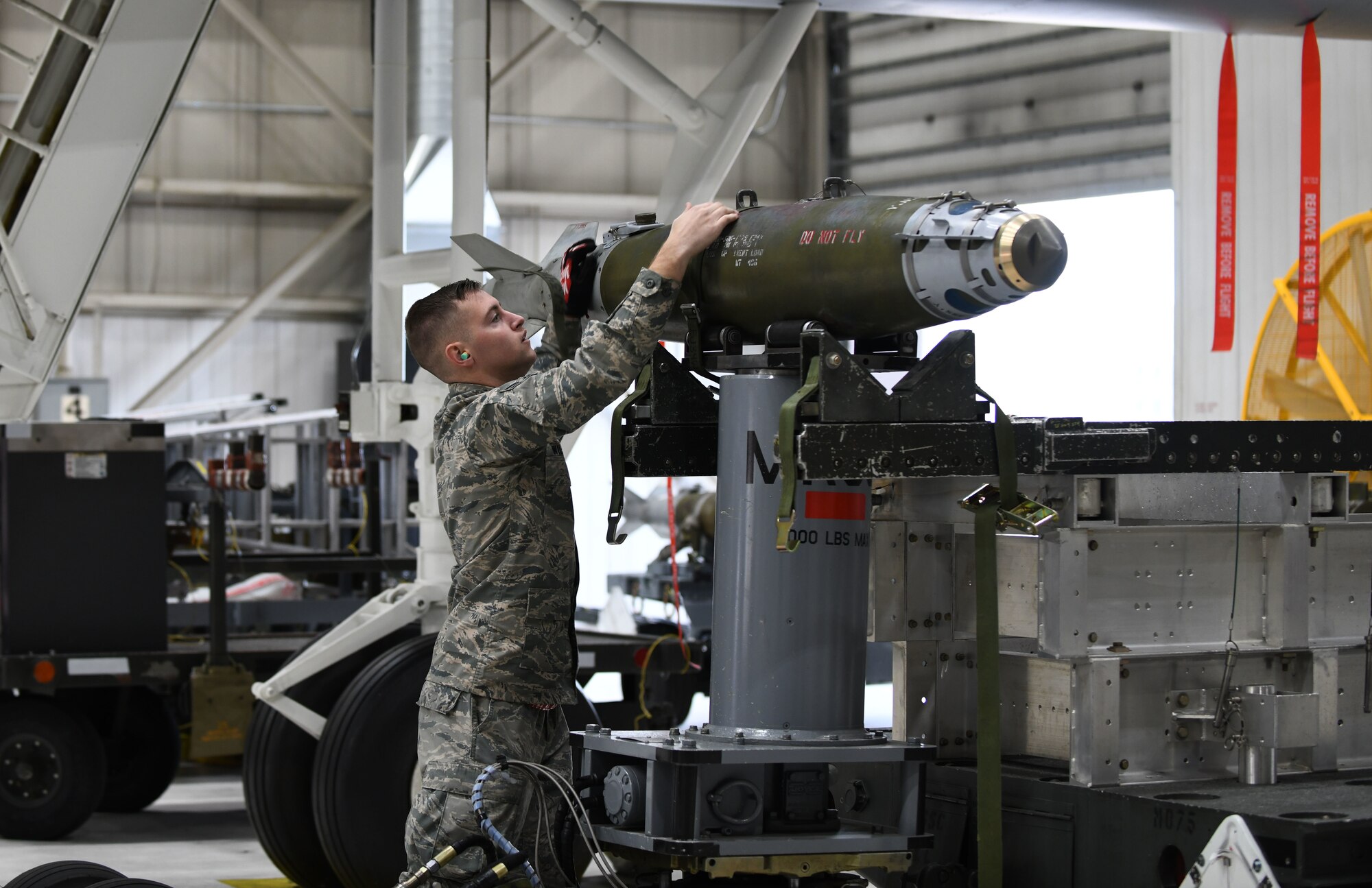 Airman 1st Class Falcon Wilson, a 34th Aircraft Maintenance Unit load crew member, inspects an inert GBU-38 Joint Direct Attack Munition for damage prior to loading it onto a simulated B-1 bomber at the annual weapons load competition at Ellsworth Air Force Base, S.D., Jan.7, 2019.  Each load crew is made up of four Airmen, with each one being responsible for a different aspect of the operation. (U.S. Air Force photo by Airman 1st Class Christina Bennett)