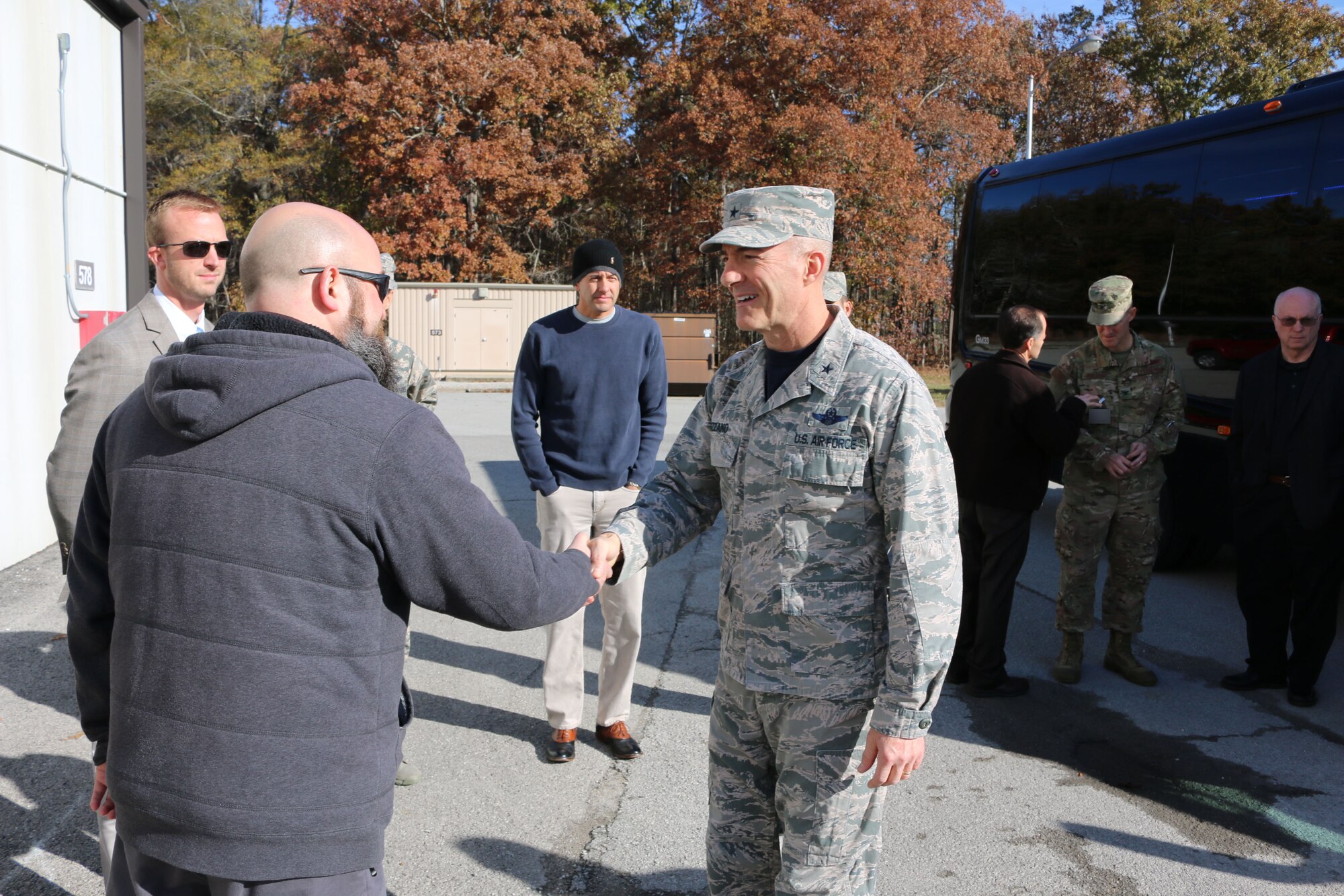 Air Force Test Center Commander Brig. Gen. Christopher Azzano, right, is greeted by Sean Smith outside of the Aerodynamic & Propulsion Test Unit during Azzano’s Nov. 16 tour of Arnold Air Force Base. Azzano and other AFTC leadership recently visited Arnold to take part in the AFTC Strategic Offsite. The Offsite was Azzano’s first since assuming the post of AFTC commander. (U.S. Air Force photo by Bradley Hicks) (This image was altered by obscuring badges for security purposes)