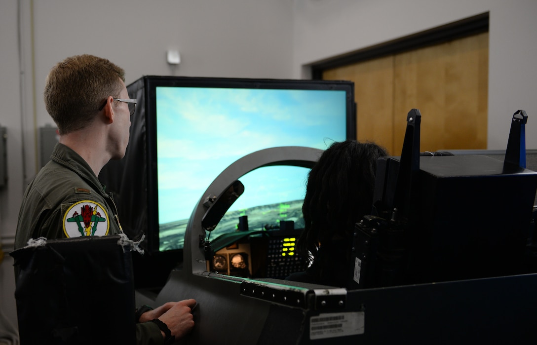 A 49th Fighter Training Squadron pilot aides a child from the Palmer Home for Children in a T-38C Talon simulator Jan. 4, 2019, at the 14th Operations Group on Columbus Air Force Base, Mississippi. The 49th FTS hosted the visit. (U.S. Air Force photo by Airman Hannah Bean)