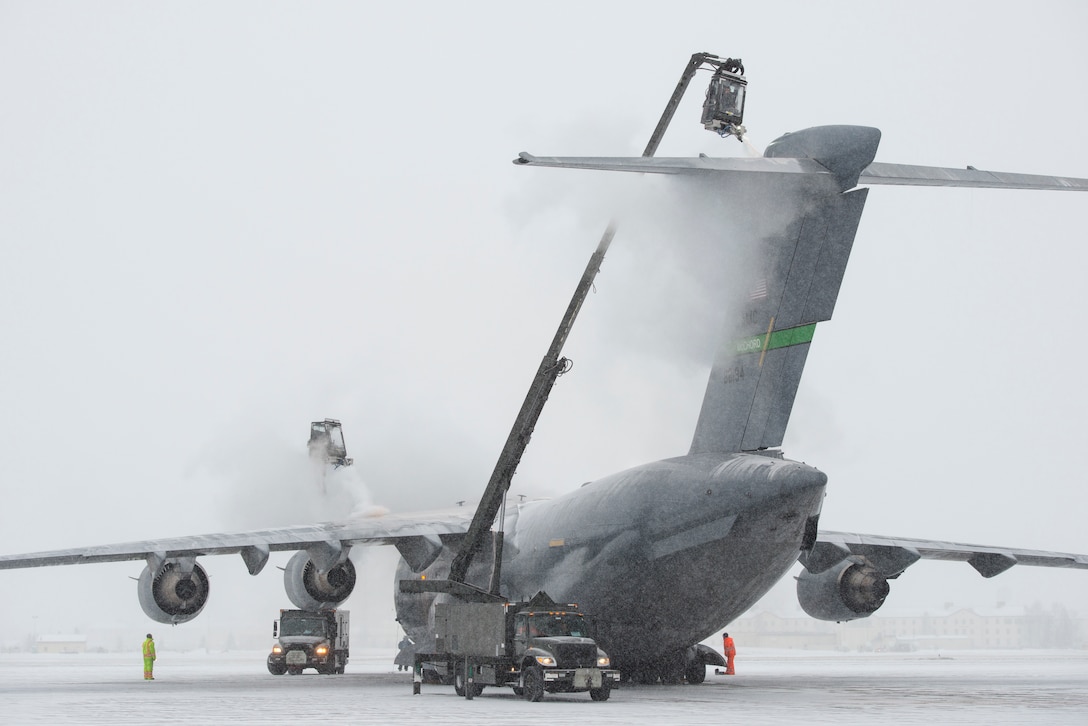 Airmen assigned to the 732nd Air Mobility Squadron de-ice a C-17 Globemaster III