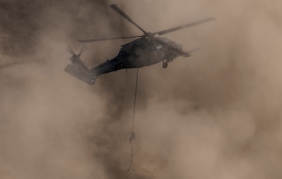 A pararescueman rappels out of an HH-60G Pave Hawk