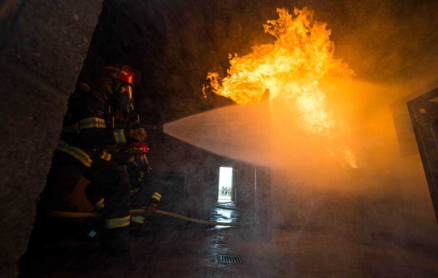 Col. Christopher Bromen, 423rd Air Base Group commander, hoses out a fire