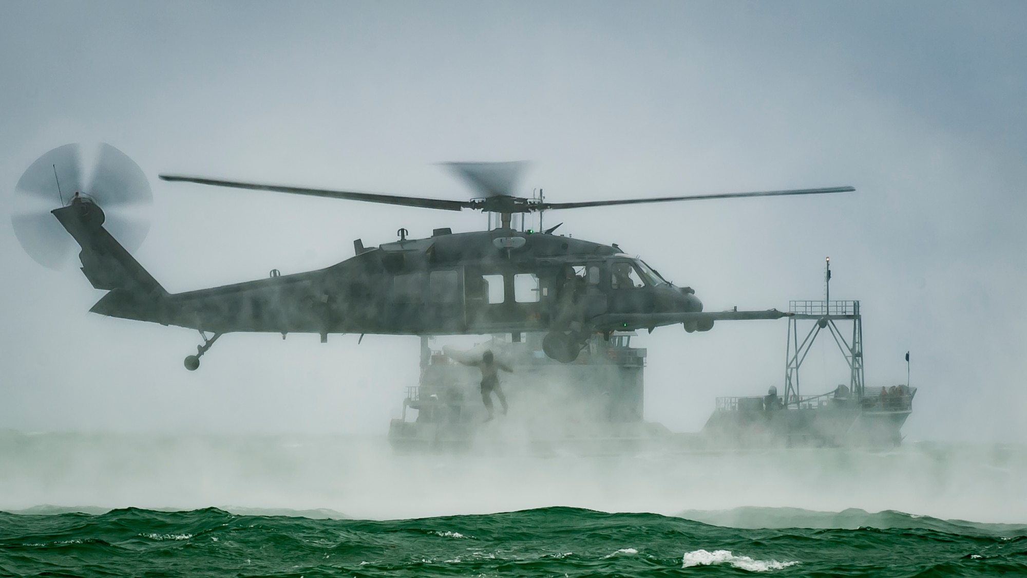 An Air Force Reserve pararescueman jumps out of an HH-60G Pave Hawk helicopter