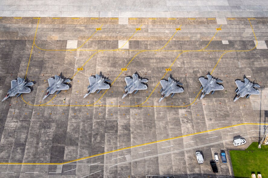 Eight U.S. Air Force F-22 Raptors sit on the flightline