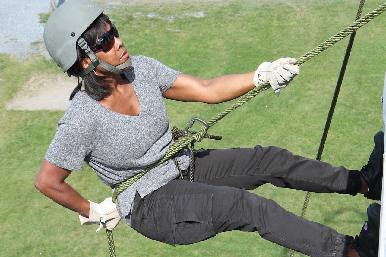 A civilian rappels down a wall