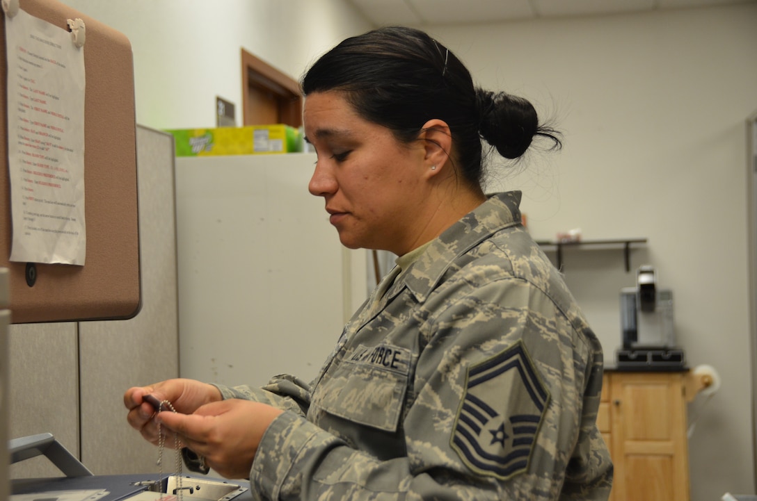 Senior Master Sgt. Livia Almandos, 161st Air Refueling Wing's Equal Employment Opportunity Specialist, displays engraving procedures on a Military Dog-Tag Embossing Machine at Goldwater Air National Guard Base, Phoenix, 06 January, 2019. Almandos volunteered to be the Unit Deployment Manager for the Wing Staff and takes pride of the undertaking as an additional duty in the New Year. (U.S. Air National Guard photo by 1st Lt. Tinashe Machona)