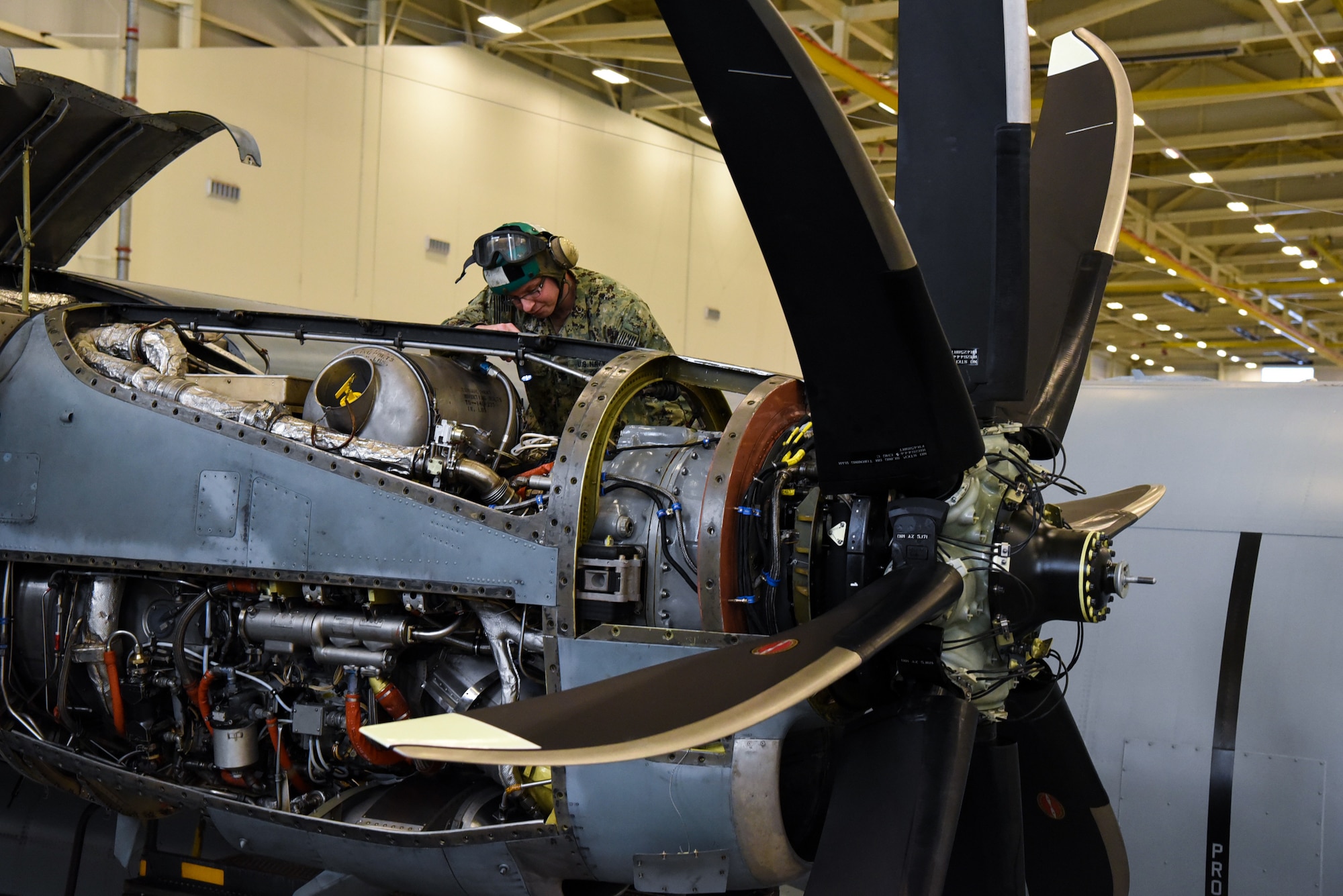 Petty Officer 1st Class William Martin, Fleet Logistics Support Squadron 64 (VR-64) aviation structural mechanic, works on an engine of a C-130 Hercules in a hangar on Joint Base McGuire-Dix-Lakehurst, New Jersey, Dec. 12, 2018. Since Martin started working in VR-64, the morale and work-ethic of the unit has increased, according to his peers, leaders and subordinates. (U.S. Air Force photo by Airman 1st Class Ariel Owings)