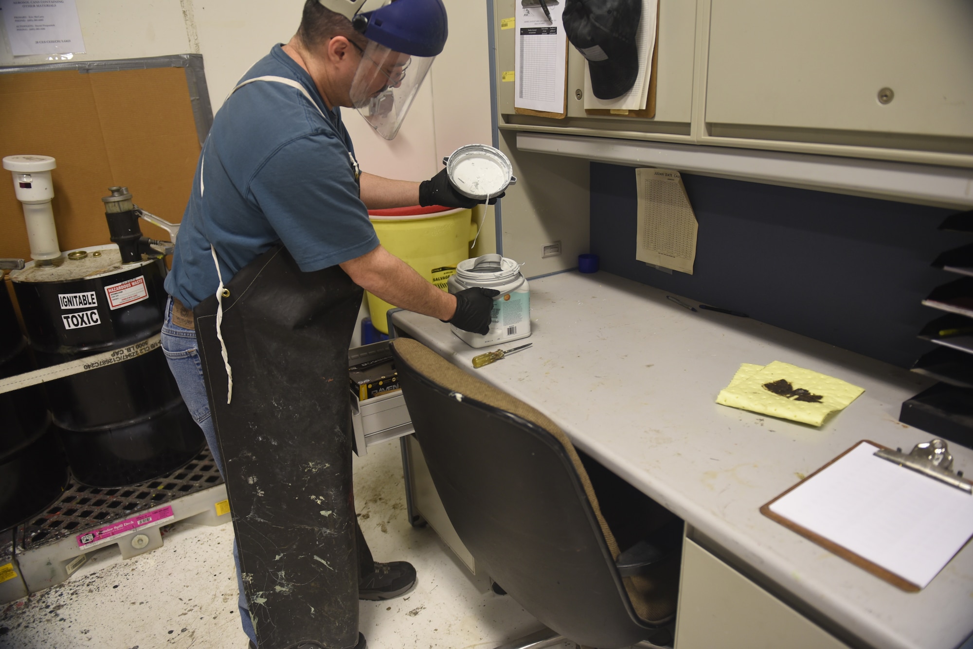 Keith Leblond, the 28th Logistics Readiness Squadron Hazmart warehouse technician, opens a bucket of paint to be disposed of at Ellsworth Air Force Base, S.D., Dec. 4, 2018. The household hazardous materials program is not available at every Air Force installation, and has only been implemented at Ellsworth for a year. (U.S. Air Force photo by Senior Airman Michella Stowers)