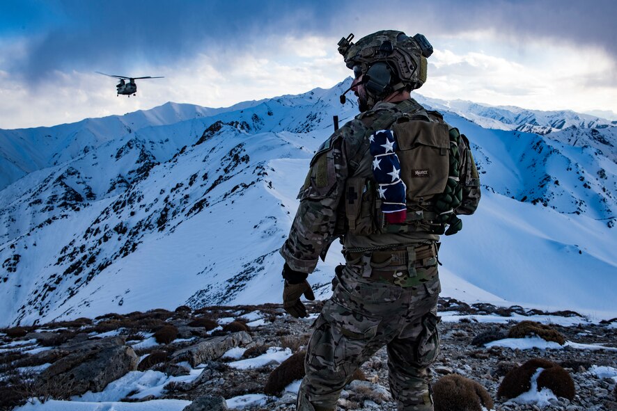 An Air Force pararescueman communicates with an Army Task Force Brawler CH-47F Chinook