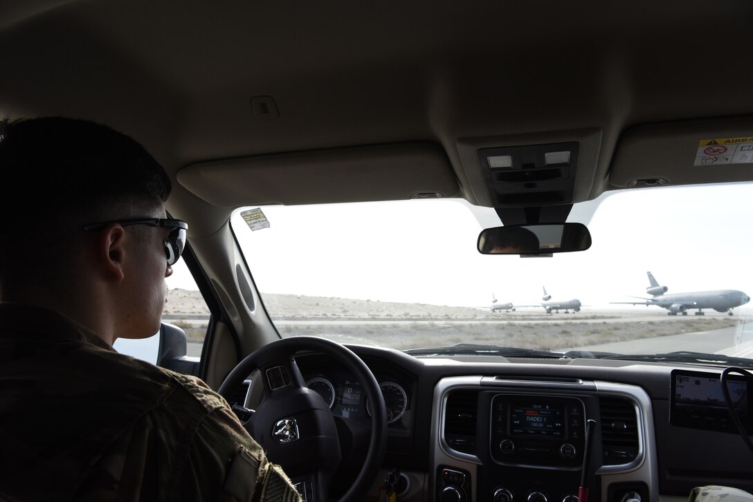 Airman Jesse Meraz, 380th EOSS airfield management operations coordinator, watches as KC-10s taxi down the runway, Jan. 8, 2019 at Al Dhafra Air Base, United Arab Emirates.