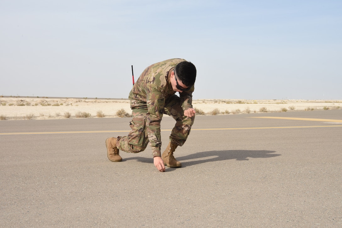 Airman Jesse Meraz, 380th EOSS airfield management operations coordinator, picks up foreign object damage during his runway inspection, Jan. 8, 2019 at Al Dhafra Air Base, United Arab Emirates.