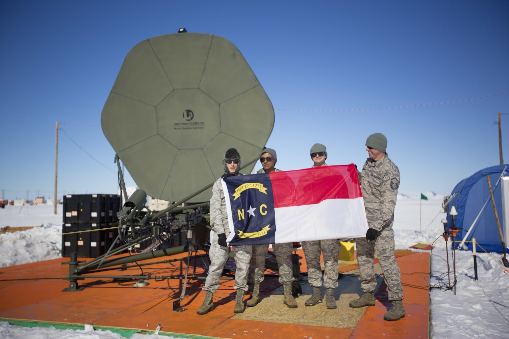 U.S. Air Force Staff Sgt. Kristofer Vandermark (far left), Staff Sgt. Titus Poulose (left), Staff Sgt. Michael Jennings (right), and Master Sgt. Chris Farnsworth (far right) of the 263rd Combat Communications Squadron, a detachment of the 145th Airlift Wing, pose for a photo while deployed to Antarctica in support of Operation Deep Freeze (ODF), at McMurdo Station, Antarctica, Dec. 1, 2018. ODF is a military mission in support of the National Science Foundation throughout the continent of Antarctica, to provide air, land, and sea support to McMurdo Station. (Courtesy photo submitted by Civ. Johnny Chiang)