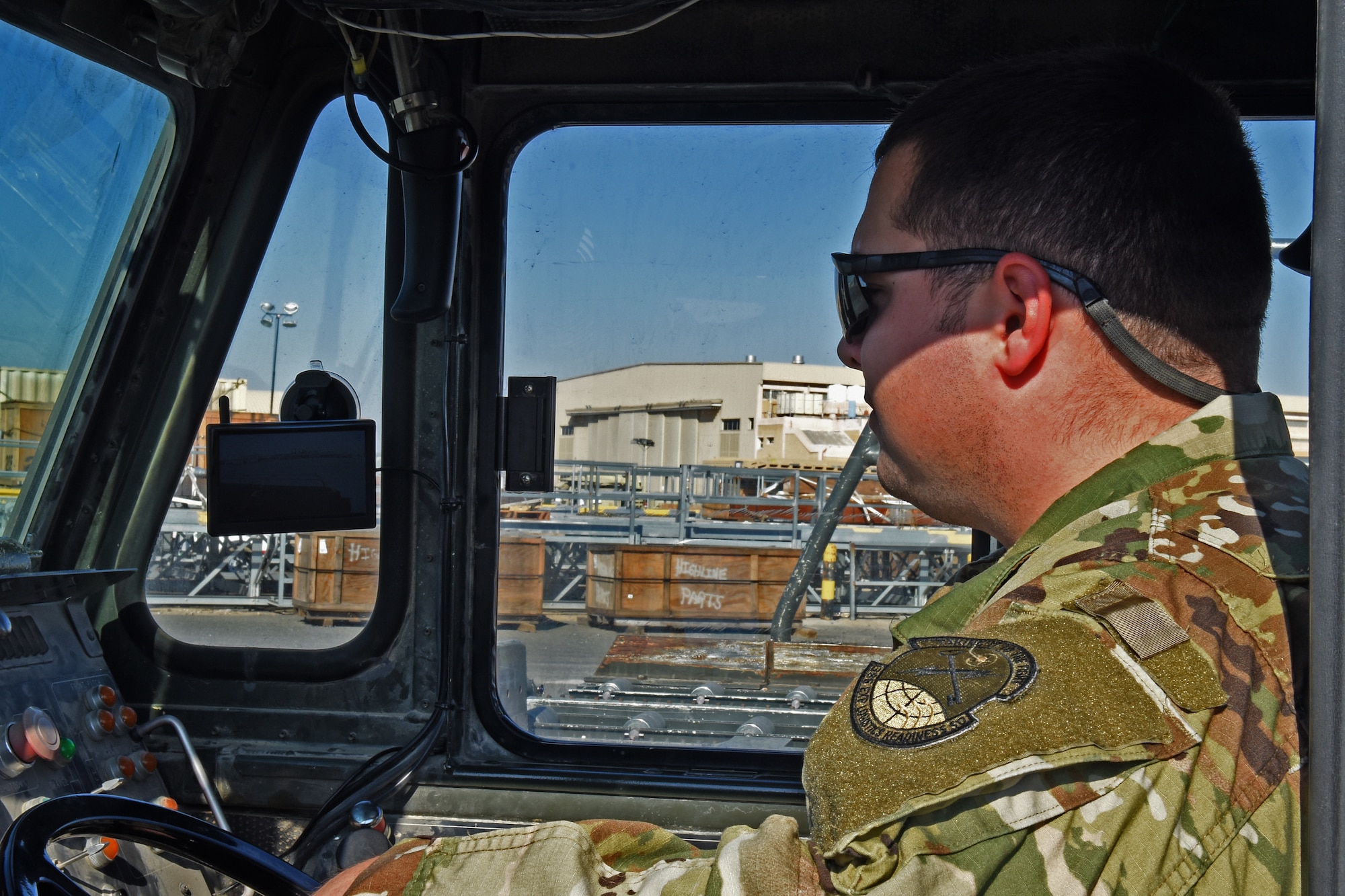 An Airman uses the backup monitor display while backing up the Tunner 60K Loader at an undisclosed location in Southwest Asia, Jan. 2, 2019. Although the camera provides the driver a view of what is behind them, they will still use the traditional spotter to assist in guiding.