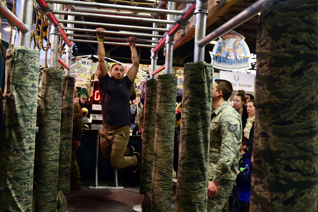 The 193rd Special Operation Wing recruiting and retention team showed off “the beast” obstacle course rig at the Harrisburg area Farm Show Complex during a recruiting event Jan. 12, 2019. The rig is nicknamed “the beast” due to its intensity. Participants had to complete push-ups, sit-ups and pull-ups, and cross monkey bars, climb over a cargo net and scale a wall as fast as possible. More than 700 participants braved "the beast" during the farm show event. (U.S. Air Force photo by Senior Airman Rachel Loftis/Released)