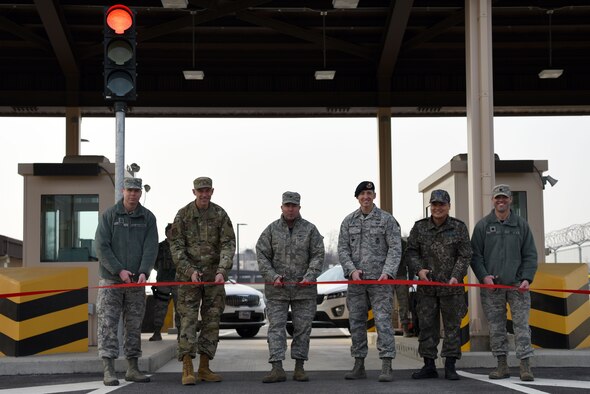 Team Osan leadership prepares to cut the ribbon at an opening ceremony for the new Morin Gate at Osan Air Base, Republic of Korea, Jan 4. 2019. The Morin Gate spent three and a half years under construction to increase antiterrorism and force protection measures while increasing throughput capacity and traffic control. (U.S. Air Force photo by Senior Airman Kelsey Tucker)